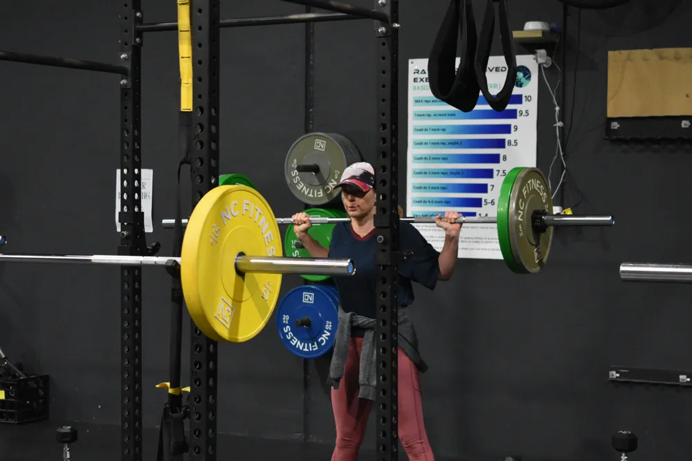 Coach reviewing a member’s progress at the rack
